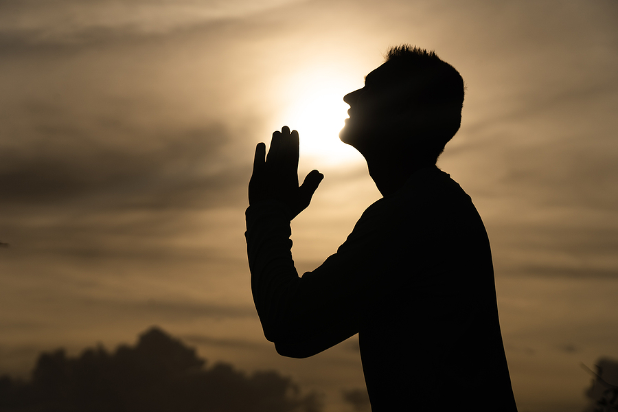 bigstock-Silhouette-Of-Man-Pray-On-Duri-424185050